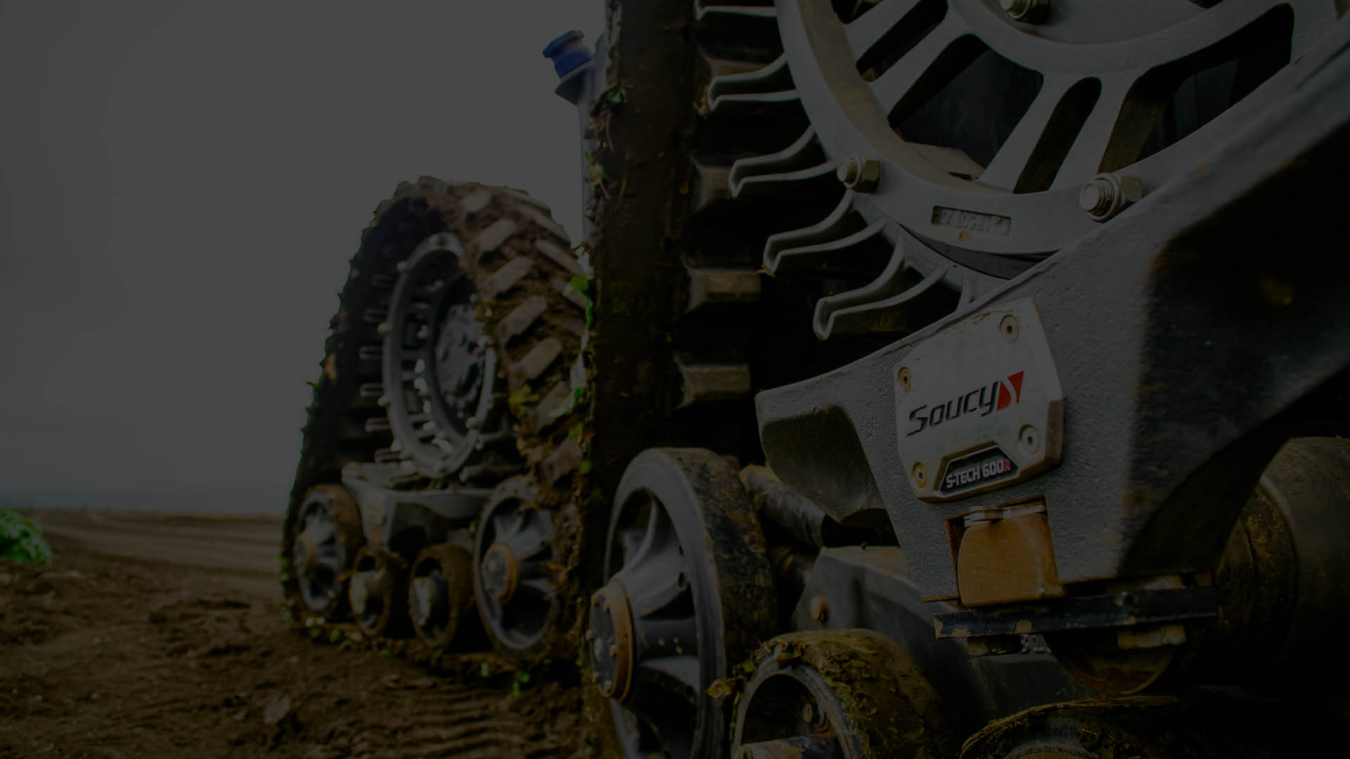 A dark picture of tractor tracks on a field